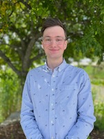 Gabe pictured against a background of greenery