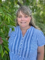 Tricia pictured against a background of greenery